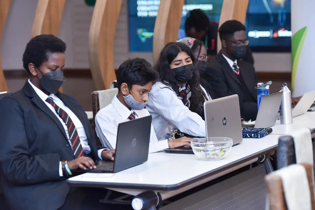 Learners working on laptops in a classroom